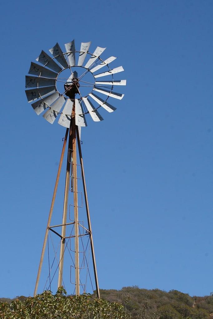 Bild von Old Cabin. old blue windmill fan rusty round blades circular
