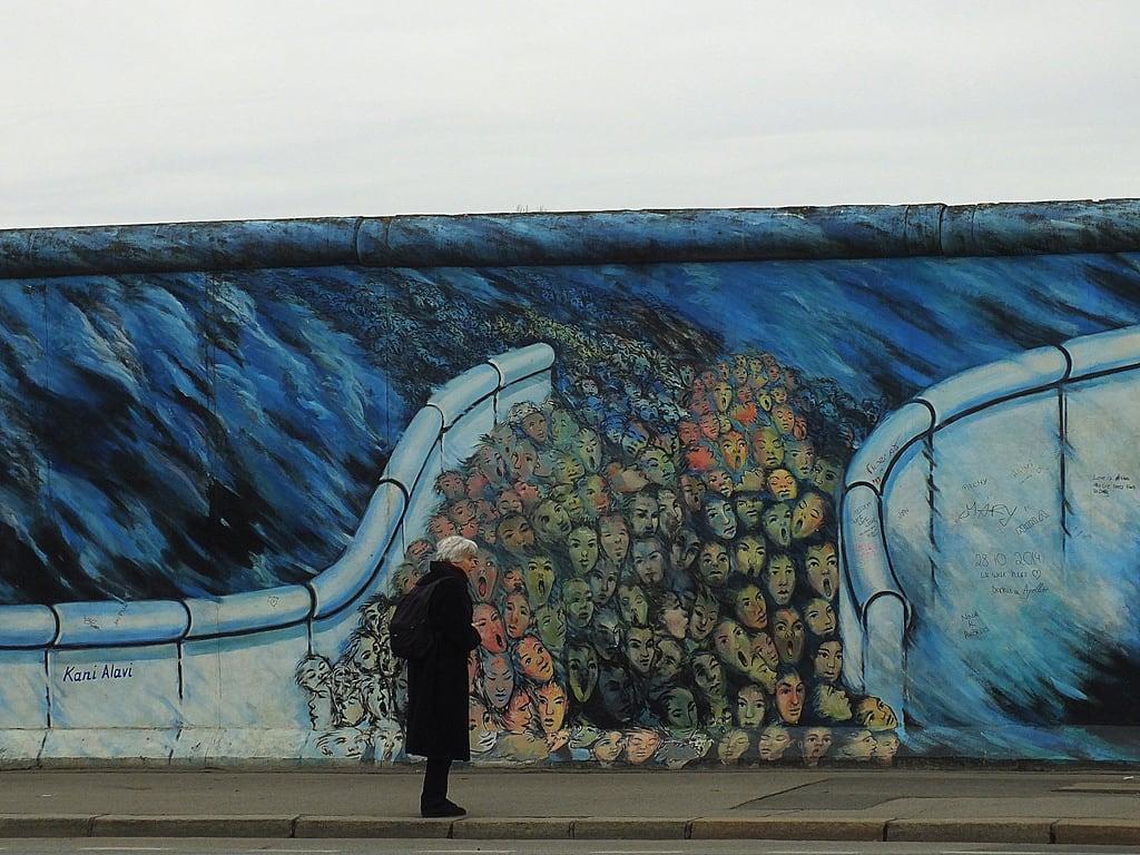 Billede af Berlin Wall. road street city blue sky people black berlin art history wall germany painting graffiti freedom europe faces pavement figure metropolis