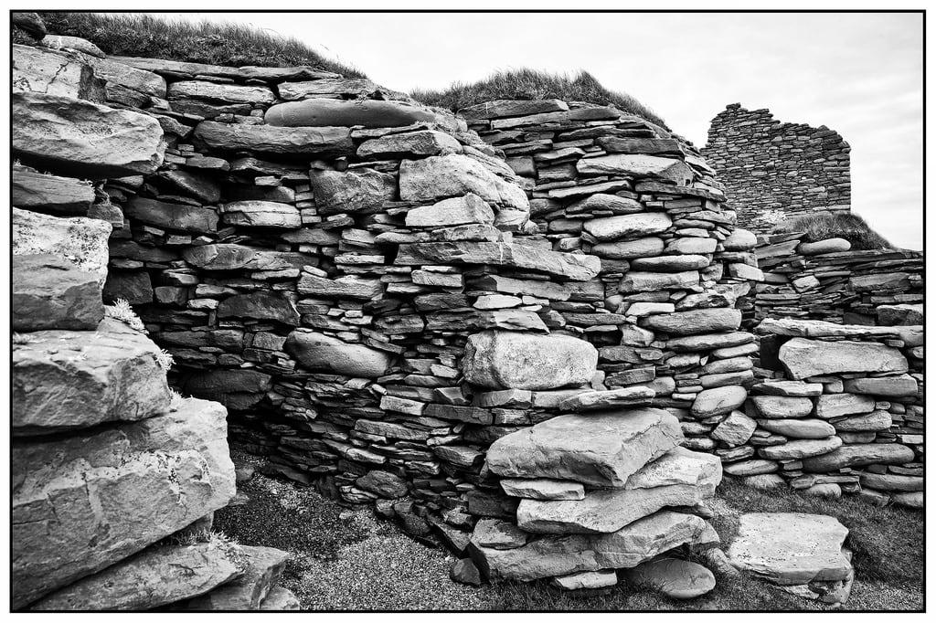 Imagine de Jarlshof. virkie scotland vereinigteskönigreich stones jarlshof ausgrabung archaeologicalsite shetland steine sw bw monochrome