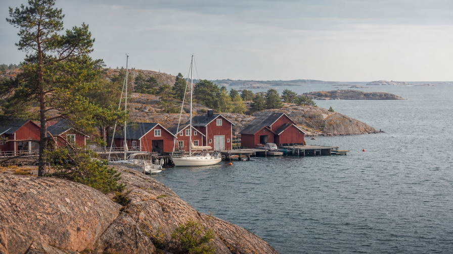 Aland-eilanden: graniet-esplanade van Mariehamn over Oostzee-chopbanden onder handels-cumulus, kopernevel van rode boothuizen naar perkamentstapels bij vestingruine Bomarsund en lint van Fasta Aland-scherrengordel bij Kobba Klintar plus weidegruis van eilandschapen in de hero - achtergrond voor EUR markt-streepjes, SEK veerboot-charter-stempelvouwen bij ponton-stapels van Westhaven van Mariehamn en rook-haring-weegbriefjesbanden.