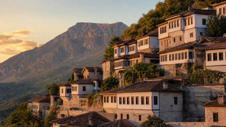 Albanië: Ottomaanse stenen bruggen over turquoise rivieren, rivierabaaien onder olijfterrassen en toppen van de Albanese Alpen in de banner - scène voor byrek-bakkerijen, raki-toasts en backpackerhostel-nachtprijzen.