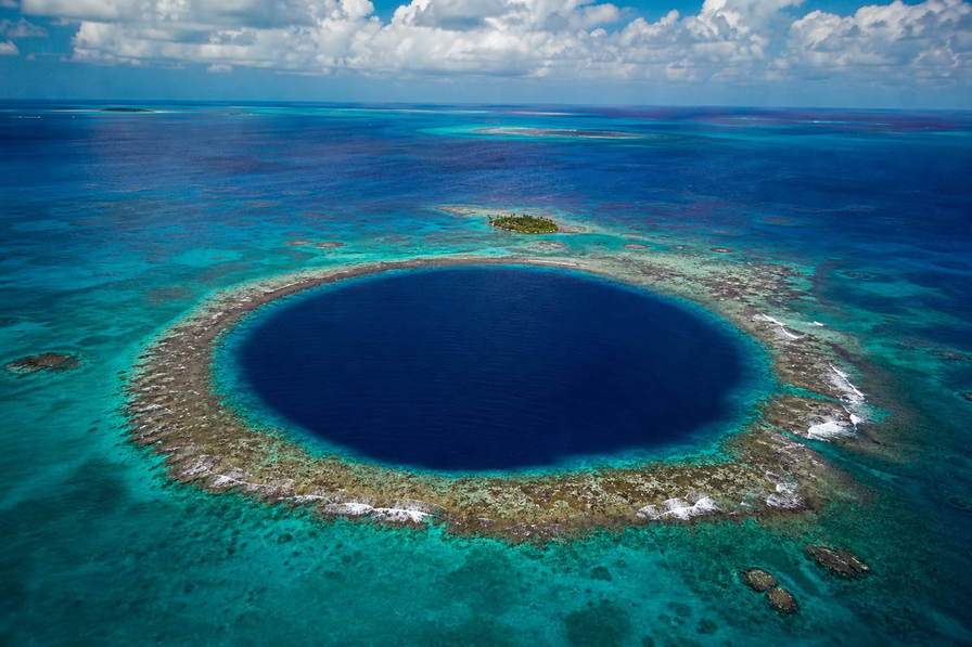 Belize: kobaltblauw oog van de Great Blue Hole dat een turkooizen riffengordel rond Lighthouse Reef vlecht onder passaat-cumulus, jadegroene rifgleuf van Hol Chan naar stapels pangas bij de steiger van Ambergris Caye en kreeft-ijskisten-glans op de stoep van Placencia met mahonie-bronsrand van Mountain Pine Ridge in de hero - achtergrond voor briefjes voor snorkeltrips in Belize-dollar (BZD), gevouwen tankbonnen voor watertaxi's en weegbriefjes voor cacaopeulen van kruidenboerderijen.