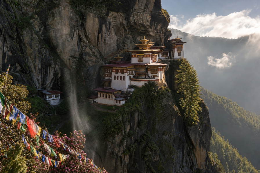 Bhutan: klif-vlecht van Taktsang Paro over moesson-cumulus-chopbanden, kopernevel van witgekalkte dzongs naar perkamentstapels bij Thimphu en gebedsvlaggenlint van Punakha bij boerderij-kade-groeven plus jeneverbes-wierookstof in de hero - achtergrond voor BTN markt-streepjes, INR grenshandel-charter-stempelvouwen bij glijkais van Phuentsholing en rode-rijst-weegbriefjesbanden.