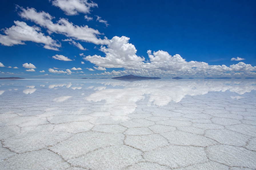 Bolivia: zeshoekige zoutscheuren in Salar de Uyuni die cactussen op Isla Incahuasi onder handels-cumulus vlechten, jadekleurige nevel aan de kam van de Cordillera Real door koperkleurige riet-nevel boven het Titicacameer naar staalkabel-stapels van Mi Teleferico boven La Paz en perkselstof van Cerro Rico in Potosí in de hero - achtergrond voor zoutwerkersbriefjes in Boliviano (BOB), gevouwen USD-tour-charter-stempels bij ijskades bij het locomotiefkerkhof in Uyuni en weegbriefjes voor textiel in Sucre.