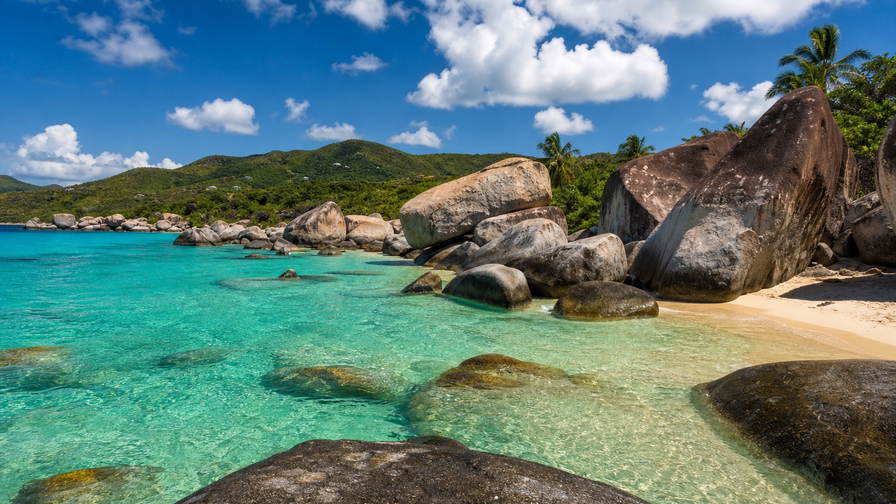 Britse Maagdeneilanden: jadekleurige ondiepten met granieten rotsblokken bij The Baths die boterachtig wit koraalzandband bij Devil's Bay onder handels-cumulus vlechten, koperkleurige sloep-nevel van Cane Garden Bay naar pastelkleurige arcade-stapels in Road Town en zee-nevel bij grotten van Norman Island met koperkleurige rumrookpluimen boven Jost Van Dyke in de hero - achtergrond voor strandbar-briefjes in Amerikaanse dollar (USD), gevouwen jachtcharter-stempels bij ijskades van jachthaven Nanny Cay en weegbriefjes voor queen conch op Virgin Gorda.