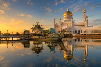 Brunei: marmeren lagunespiegels in Bandar Seri Begawan die reflecties van de puur gouden koepel van de Omar Ali Saifuddien-moskee vlechten, schaduwen van stelzenpaden in Kampong Ayer richting ambuyat-stoomspiralen op de nachtmarkt van Gadong en nevelbanden van boomkroonpaden in Ulu Temburong in de hero - achtergrond voor weegbriefjes voor keropok ikan in Bruneise dollar (BND), stapels bliklipjes voor suiker van sagopalm en gevouwen taxameterbonnen met gesubsidieerde tarieven.