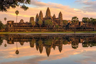 Cambodja: lotustorens van Angkor Wat die zijderoze vijverspiegelingen vlechten bij ochtendlicht in de jungle, palen van stelzenhuizen op het Tonlé Sap richting weefschiet-geratel in de gangen van de Russian Market in Phnom Penh en zilvermist boven rijstvelden in Battambang in de hero - achtergrond voor streepjes bij noedelkarren in Cambodjaanse riel (KHR), waszegels op potten met prahok-pasta en gevouwen bonnen aan keycords voor tempelpassen.