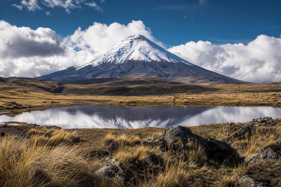 Ecuador: sneeuwkap van vulkaan Cotopaxi die goudkleurig paramo-gras onder handels-cumulus vlecht, jadekleurige nevel boven het kratermeer Quilotoa door koperkleurige drukte van textiel op het plein van Otavalo naar kalkstenen arcade-stapels bij San Francisco in Quito en koperkleurige stoompluimen boven de Amazonerivier Napo in de hero - achtergrond voor marktbriefjes in Amerikaanse dollar (USD), gevouwen charter-stempels bij ijskades op de Malecón in Guayaquil en weegbriefjes voor Panamahoeden uit Cuenca.