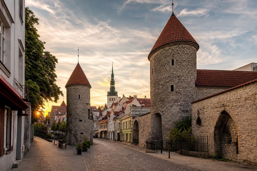 Estland: middeleeuwse Hanzepakhuizen in de Tallinse haven, mist op vlonderpaden door hoogveen en dennenduinen aan de Oostzee in de banner - scène voor roggebrood, sauna-toeslagen en ferryhut-upgrades.