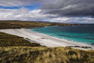 Falklandeilanden: Zuid-Atlantische kwartswitte stranden vlechten Gypsy Cove golfbanden onder handelsstapelwolken, kopernevel boven Stanleyhaven naar vuurtoren Kaap Pembroke en perksellint van Darwin-nederzetting op turf bij Volunteer Point plus stof van schapendips op Carcass Island in de hero - achtergrond voor FKP lodge-streepjes, GBP cruise-charter-stempelvouwen bij helling-glijkais naar Mount Pleasant en wol-weegbriefjesbanden op Saunders Island.