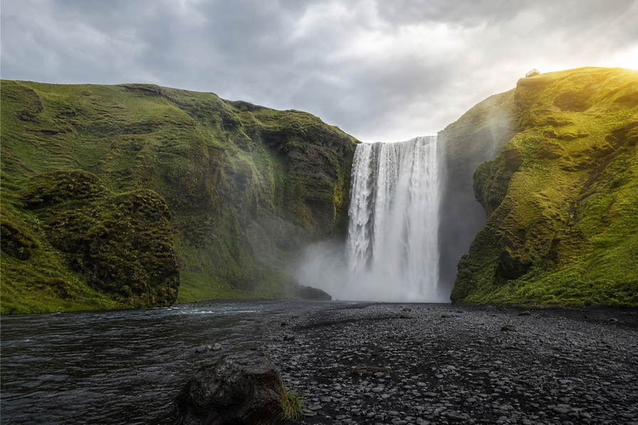 IJsland: lavavelden, gordijnwatervallen en mosgroen hoogland achter golfplaten in Reykjavik in de hero - kader voor hotdog-kassa's, Bonus-tassen en camperdiesel.