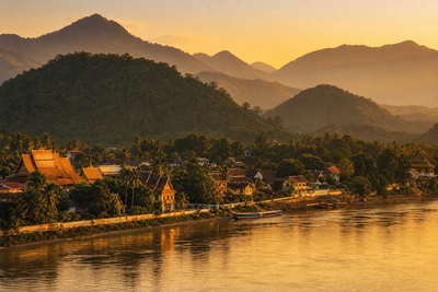 Laos: bronzen Mekong-stromingen in Luang Prabang die teak longtail-kielzicht vlechten naar de vergulde stupa-kam op Phou Si, Patuxai-boog in Vientiane in kalknevel richting stoom van kleefrijst op ochtendmarkten en zilveren rivierbanden met tubing in Vang Vieng in de hero - achtergrond voor streepjes bij tam mak houng-vijzels in Laotiaanse kip (LAK), weeglabels voor geweven zijden strengen en gevouwen kartonbonnen aan slowboat-steigers.