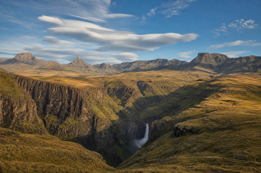 Lesotho: kwarts-vlechtwerk van Maluti-helling over Katse-stuwmeer golfbanden onder handelsstapelwolken, kopernevel bij Thaba Bosiu naar haarspeldbochten van Sani Pass en perkamentstapels aan bochten, mistlint van Maletsunyane-waterval boven plateau van Maseru plus proteastof in nationaal park Sehlabathebe in de hero - achtergrond voor LSL kudde-streepjes, ZAR ponytrek-charter-stempelvouwen bij slipvlak bij lodge in Malealea en mais-weegbriefjesbanden bij Mohale-dam.