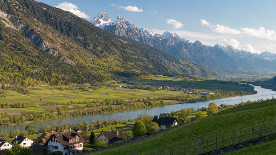 Liechtenstein: wijngaardstrepen in de Rijnvallei die alpenbos-schaduwen vlechten, besneeuwde kammen boven dorpjes op Vaduz-schaal en zilver rivierglans in hooggebergte-licht in de hero-foto - visuele intro voor supermarktbezoek in Zwitserse franken (CHF), fonduestube-prijsvergelijkingen en huur-ladders voor appartementen aan de Rijn.