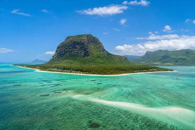 Mauritius: lagunespiegel bij Le Morne onder de basaltpiek Le Morne Brabant, stoom van dholl puri op de centrale markt van Port Louis bij zonsopgang en haarspeldbochten door theeplantages richting Grand Bassin in de hero - achtergrond voor rougaille-inktvis van de grill, kassabonnen in Mauritiaanse roepies (MUR) en weekprijzen voor kustvilla's met tweetalige contracten.
