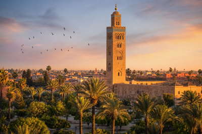 Marokko: leerverfbaden in de medina van Fez, haarspeldbochten over de Hoge Atlas en rookpluimen boven het Jemaa el Fna in Marrakesh in de hero - achtergrond voor tajine-deksels, slakkenkraampjes en kamers rond de binnenplaats van een riad.