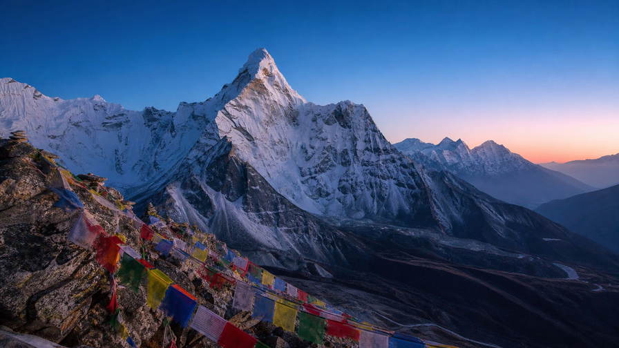 Nepal: ijsfluiten van Ama Dablam die gebedsvlaggenkam boven veekralen van Namche Bazaar kaderen, oogstrepen van de Boudhanath-stupa in Kathmandu richting petroleumlampgloren in Everest-theehuizen en turkooizen roeiriemeling op Fewa-meer in Pokhara in de hero - achtergrond voor gevouwen TIMS-trekkingvergunningen in Nepalese roepies (NPR), brandstofbonnetjes voor yakmest en stapels vinkjes op stoommanden voor momo.