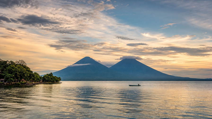 Nicaragua: jadegroen bord van het Meer van Nicaragua dat tweelingvulkaansymmetrie van Ometepe vlecht onder cumulusstapels, pastelkleurige koloniale arcade-nevel in Granada naar zwavelstoom aan de Masaya-caldera en witte gevelgoot van de kathedraal in León met gouden golflijnen in San Juan del Sur in de hero - achtergrond voor marktbrieven voor vigoron in córdoba (NIO), gevouwen stempels van zakken op chicken buses en douanestrepen voor Flor de Caña-rumflessen.