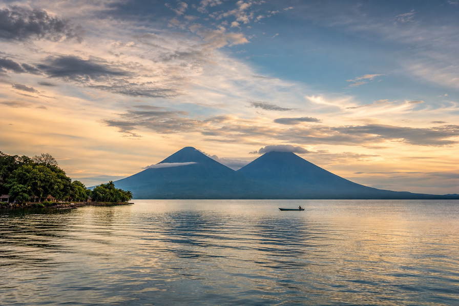 Nicaragua: jadegroen bord van het Meer van Nicaragua dat tweelingvulkaansymmetrie van Ometepe vlecht onder cumulusstapels, pastelkleurige koloniale arcade-nevel in Granada naar zwavelstoom aan de Masaya-caldera en witte gevelgoot van de kathedraal in León met gouden golflijnen in San Juan del Sur in de hero - achtergrond voor marktbrieven voor vigoron in córdoba (NIO), gevouwen stempels van zakken op chicken buses en douanestrepen voor Flor de Caña-rumflessen.