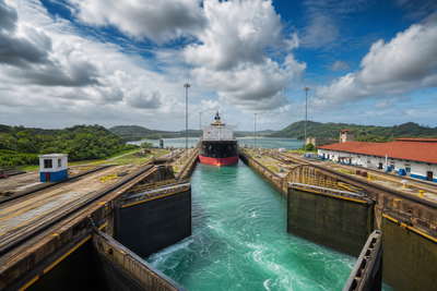 Panama: kobaltlint van de Miraflores-sluis op het Panamakanaal dat gloed van neo-Panamax-schepen vlecht onder equatoriale cumulus, oker nevel van koloniale arcaden in Casco Viejo naar spiegeling van de zeedijk van de Cinta Costera en krijtwitte palm-eilandjes van San Blas met perksels van Geisha-microlots uit Boquete in de hero - achtergrond voor buseta-briefjes in balboa en US-dollar (PAB/USD), gevouwen stempels van het kanaalbezoekerscentrum en weegbriefjes voor corvina op ijs op de vismarkt.