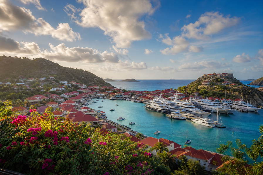 Saint-Barthélemy: koloniale rood-dak-vlecht van Gustavia over Caraïbische chopbanden onder handels-cumulus, kopernevel van Shell Beach naar perkamentstapels bij baai Colombier en lint van Fort Oscar bij mega-jacht-ponton-groeven plus bougainvillea-stuifmeel op helling in de hero - achtergrond voor EUR markt-streepjes, USD jacht-charter-stempelvouwen bij glijkais bij Quai du General de Gaulle en creoolse-kruidenmarkt-weegbriefjesbanden.