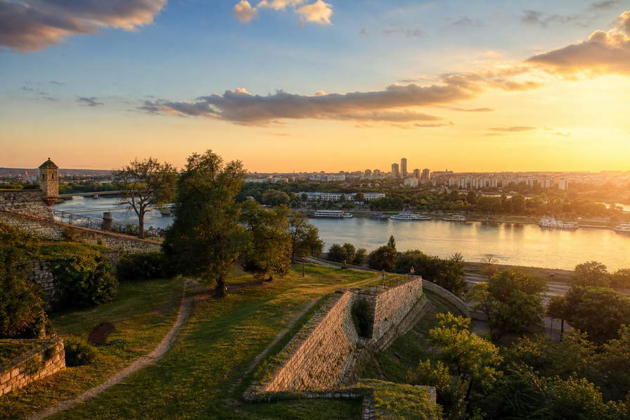 Servië: vestingmuren aan de rivier in Belgrado, rookterras-kafana's en Šumadija-fruithellingen in de banner - kader voor ćevapi-schotels, rakija-rondes en huur in Nieuw Belgrado.