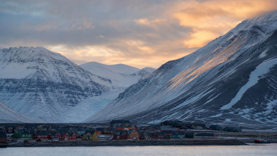 Svalbard en Jan Mayen: houten esplanade van Longyearbyen over chopbanden van Adventfjorden onder handels-cumulus, kopernevel van gletsjer naar perkamentstapels bij landingsbaan Ny-Alesund en lint van smeltwater van Isfjord bij gelaagde ijsgroeven plus weidegruis van rendierweiden in de hero - achtergrond voor NOK markt-streepjes, EUR expeditie-cruise-charter-stempelvouwen bij ponton-stapels van steenkoolkaai en rook-kabeljauw-weegbriefjesbanden.