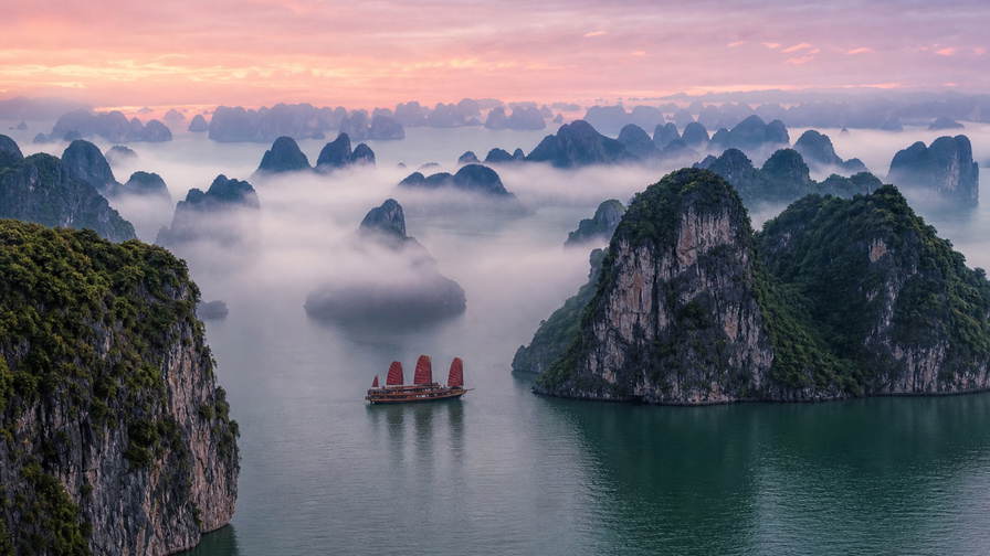 Vietnam: kalkstenen eilanden in Ha Long Bay die jadegetij-vingerafdrukken vlechten door zijdeachtige ochtendmist, pho- en druppelkoffiestoom bij Train Street in Hanoi richting draakboot-kielzicht met lotusblaadjes op de Parfumrivier in Hue en auberginekleurige lantaarnreflecties op het water in Hoi An in de hero - achtergrond voor streepjes op pho-kraampjes in Vietnamees dong (VND), weeglabels voor cashewnoten in bulk en kartonstapels voor peddelhuur op de drijvende Mekong-markt.