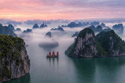 Vietnam: kalkstenen eilanden in Ha Long Bay die jadegetij-vingerafdrukken vlechten door zijdeachtige ochtendmist, pho- en druppelkoffiestoom bij Train Street in Hanoi richting draakboot-kielzicht met lotusblaadjes op de Parfumrivier in Hue en auberginekleurige lantaarnreflecties op het water in Hoi An in de hero - achtergrond voor streepjes op pho-kraampjes in Vietnamees dong (VND), weeglabels voor cashewnoten in bulk en kartonstapels voor peddelhuur op de drijvende Mekong-markt.